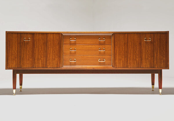 Temprano aparador G Plan de la línea Tola & Black de 1.958. Sencillo y elegante, acabado en Tola y caoba, cada detalle está cuidado con mimo, como los tiradores dorados. Puertas plegables laterales que ocultan los espacios de almacenaje y 3 cajones centrales, el superior forrado de fieltro negro para albergar la cubertería. Medidas: 1,91×0,44×0,77(h) m